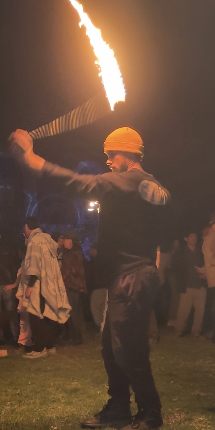 Jono Mitchell performing fire poi at a live nighttime event